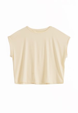 Luźna bluzka z krótkim rękawem i okrągłym dekoltem w jasnobeżowym kolorze, o pudełkowatym, oversize kroju i minimalistycznym wykończeniu.