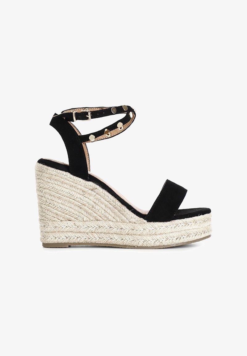 Sorte ruskind wedge sandaler med en vævet rebbund, der har en ankelrem prydet med guldtonede nitter og en enkelt tårem.