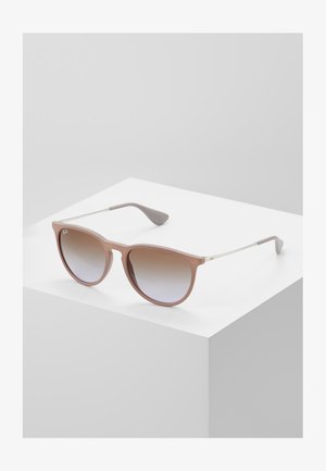 Óculos de sol com uma armação em plástico rosa mate, lentes em degradê e elementos em metal prateado. Formato de olho de gato com hastes curvas e texturas suaves.