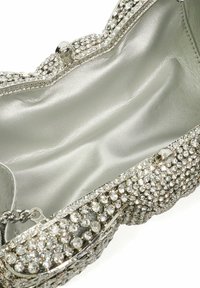 Silver clutch bag featuring a textured exterior adorned with clear rhinestones, a smooth silver interior, and a clasp closure.
