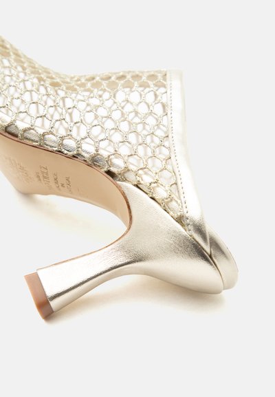 Madala kassipoja kontsaga kinga, millel on metallik-kuldne viimistlus ja avatud võrgukangas mesilase mesi-kujundusega.