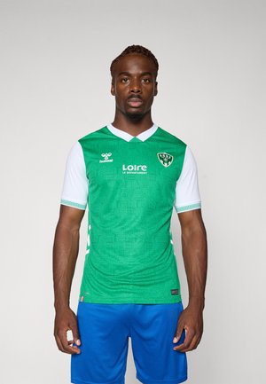 Green soccer jersey with white sleeves and v-neck. Features textured pattern, logo on chest, and team name. Paired with blue shorts.