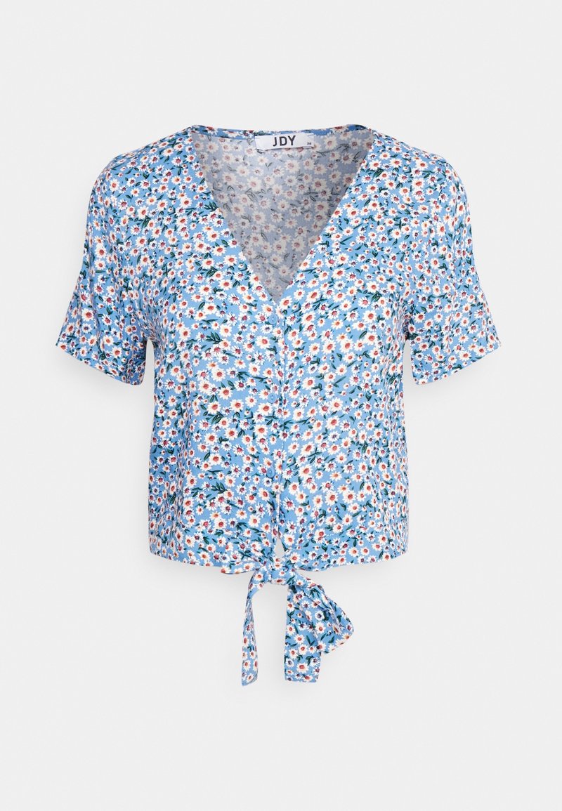 Blouse bleue à manches courtes avec imprimé marguerites blanches et rouges, col en V, boutons sur le devant et nœud noué à l’ourlet.