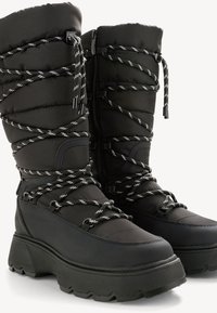 Zwarte winterlaarzen met een puffy nylon bovenkant en dikke rubberen zolen. Voorzien van gevlochten veters en een ritssluiting voor een veilige pasvorm.