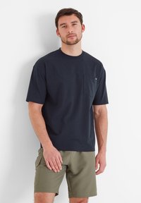 Navy blue cotton t-shirt with short sleeves, featuring a left chest pocket. Paired with olive green shorts, relaxed fit, minimal design.