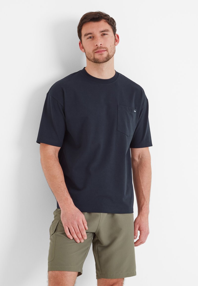 Navy blue cotton t-shirt with short sleeves, featuring a left chest pocket. Paired with olive green shorts, relaxed fit, minimal design.
