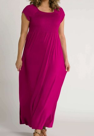 Długa sukienka w kolorze fuksji z rękawami typu cap, marszczonym górnym stanem, płynną spódnicą, miękkim materiałem i bocznymi rozcięciami, noszona z beżowymi sandałami.