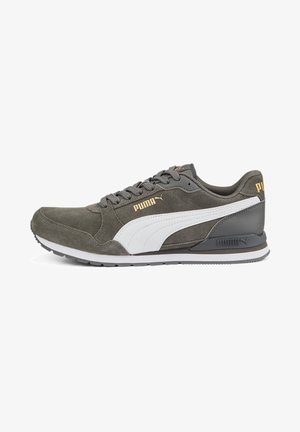 Szary zamszowy sneaker Puma z białym paskiem z boku, złotym logo Puma, szarymi sznurowadłami i czarną podeszwą na białym tle.