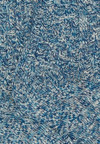 Sciarpa lavorata a maglia con un pattern variegato blu e bianco. La texture è morbida, con disegni geometrici creati da diverse tecniche di punto.