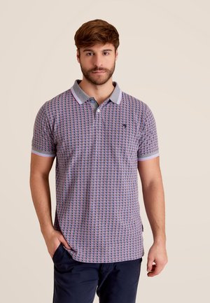 Polo-shirt avec un motif géométrique rose, bleu et blanc. Comprend un col gris avec des rayures colorées et des manches courtes.