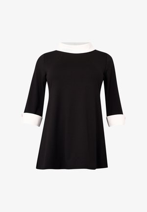 Tunique noire à manches longues avec des poignets repliés blancs et un col montant blanc, présentant une coupe ample et légèrement évasée.