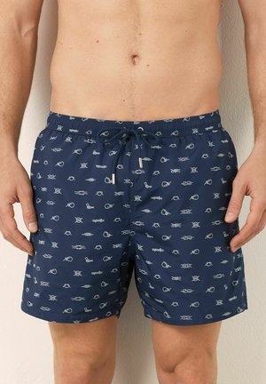 Costumi da bagno navy con un motivo a pesci e nodi ripetuto, realizzati in tessuto leggero con vita elastica e cordino regolabile.