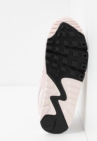 Semelle de sneaker Nike en noir et rose. Caoutchouc texturé avec une prise à motifs en diamant et le logo swoosh. Design incurvé avec des matériaux superposés.