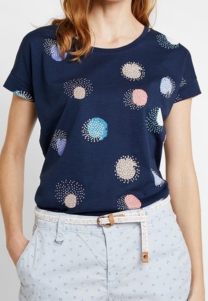 Granatowa koszulka z krótkim rękawem z wielokolorowymi kropkami w różnych rozmiarach, wykonana z miękkiego materiału o luźnym kroju.