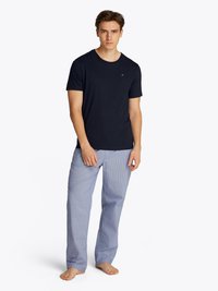 T-shirt a girocollo navy abbinato a pantaloni da lounge a quadri azzurri chiari. Tessuto morbido con una vestibilità rilassata, con un piccolo logo sulla maglietta.