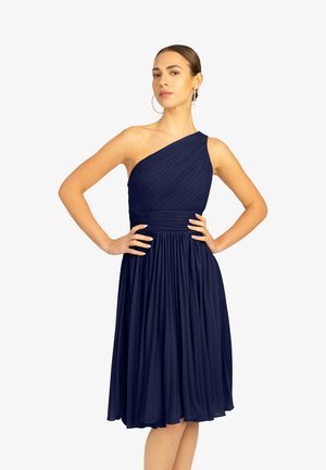 Robe bleu marine à une épaule, faite de tissu plissé avec un buste cintré et une jupe évasée. Présente une taille bien définie et une texture lisse.