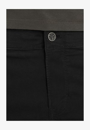 Zwarte denim jeans met een metalen knoopsluiting, contrasterende stiksels en een voorzak met een gladde textuur en een minimalistisch ontwerp.