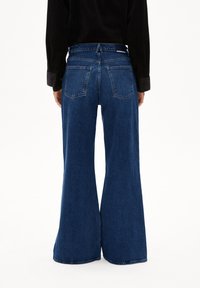 Brede spijkerbroek van blauw denim met een hoge taille, voorzien van twee achterzakken en een nette zoom. Gemaakt van klassieke geweven denimstof.