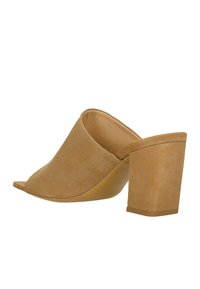 Mules en suède beige à bout ouvert avec un solide talon bloc haut. Texture lisse, tige sans couture et semelle en caoutchouc robuste pour une bonne adhérence.
