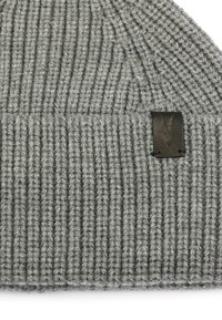 Bonnet en tricot gris avec texture côtelée, ornée d'un petit patch en cuir noir avec un design en relief à l'avant.