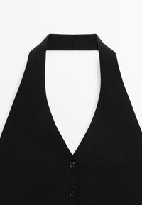 Black knitted halter vest with a deep V-neck, featuring a button closure, smooth texture, and a minimalist design.