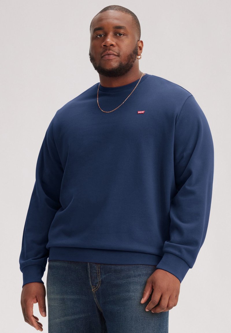 Navy blue sweatshirt made of soft fabric with a round neckline, ribbed cuffs, and a small red logo on the left chest.