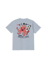 Ανοιχτό μπλε μπλουζάκι με ένα χαμογελαστό ροζ χταπόδι που φοράει μια κορδέλα στο κεφάλι, κρατώντας μια κάθετη ιαπωνική σημαία, με κείμενο που αναφέρεται στο Takoyaki Osaka.