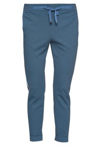 Niebieskie joggery w wzory z regulowanym paskiem i zwężającymi się nogawkami.