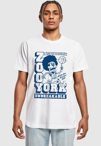 White cotton t-shirt featuring a blue graphic design of a basketball player with an afro, text reading "NEW YORK CITY DUNKERS" and "UNBREAKABLE."