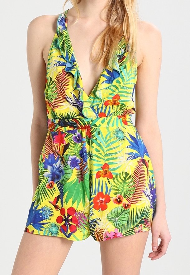 Yellow floral romper featuring vibrant tropical prints, deep V-neck, ruffle detail, and a cinched waist with short shorts.