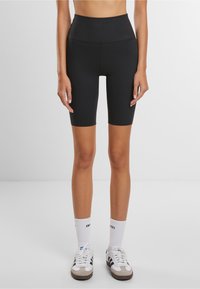 Schwarze, hochtaillierte Radlerhosen aus dehnbarem Stoff, mit einer glatten Textur und einem figurbetonten Design, das knapp über das Knie reicht.