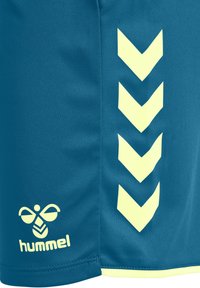 Blue fabric with four downward chevron stripes and a stylized bee logo above the brand name "hummel" in light yellow.