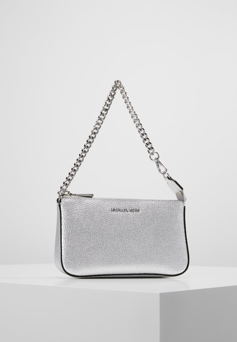 Zilverkleurige gestructureerde leren polsband met een zilveren kettinghandgreep en ritssluiting, tentoongesteld op een witte sokkel tegen een effen achtergrond.