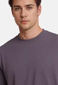 Purple crewneck sweatshirt made of soft, smooth fabric. Features a ribbed neckline and a simple, seamless design.