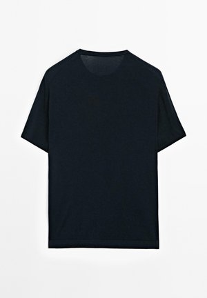 Czarny t-shirt z krótkim rękawem i okrągłym dekoltem, wykonany z gładkiej tkaniny. Projekt cechuje się luźnym krojem i subtelnymi przeszyciami.