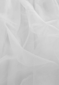 Witte doorschijnende stof met een lichte, translucente textuur, met zachte plooien en zachte golven, wat zorgt voor een delicate en luchtige uitstraling.