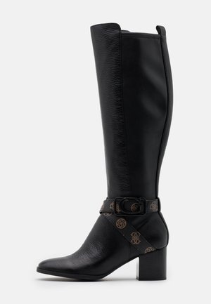 Botte haute en cuir noir avec un talon bloc moyen, un bout pointu et une bride décorative ornée d'une boucle et d'un motif monogramme marron.