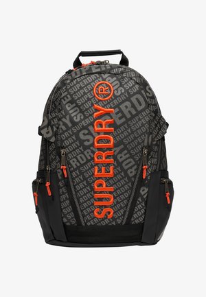 Zaino nero con la parola "SUPERDRY" in arancione, dotato di molteplici scomparti con cerniera, una maniglia ergonomica e spallacci regolabili.