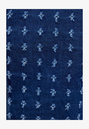 Tissu en denim avec une base bleu foncé, présentant un motif répété d'accents cousus bleu clair et de petits détails effilochés partout.