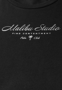 Černé bavlněné tričko s bílým textem: "Malibu Studio", "NAJDI SPOKOJENOST", "Palm Club" a malou ikonou palmy.