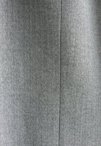 Tejido de patrón espiga en gris y negro, con una textura suave y un ligero brillo, que presenta una apariencia limpia y ajustada.