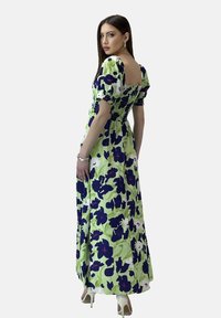 Maxikleid in Hellgrün mit floralem Muster in Dunkelblau und Lila. Es hat Puffärmel, einen quadratischen Rückenausschnitt und ist tailliert.