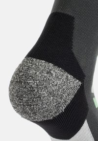 Calzini neri e grigi con tallone testurizzato che presenta un'area nera solida, un motivo grigio cucito e un accento verde.