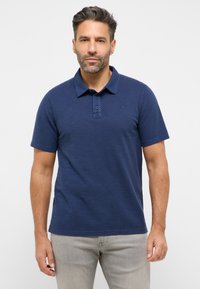 Tamsiai mėlyna trumpomis rankovėmis polo marškinėliai su raštuotu apykakle, trijų mygtukų užsegimu ir subtiliu tekstūru. Prie krūtinės esantis logotipo akcentas.