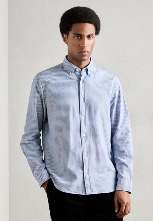 Chemise à boutonner en rayures bleu clair et blanches, en coton, avec un col, des manches longues et une coupe classique.