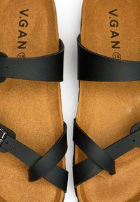 Black cross-strap sandals with a cork footbed. Features metallic buckle and textured brown sole. Marked with 'V.GAN' and size 38.