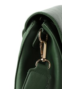 Zelená kožená kabelka s hladkým povrchem, zlatou kovovou sponou a zaoblenými okraji, s odnímatelným popruhem připevněným na boku.