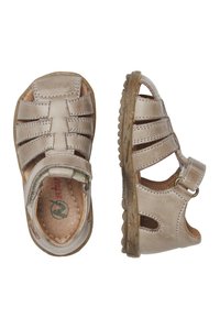 Ljust beige lädersandaler med stängd häl, öppen tå, flera remmar, justerbar spänne och texturerad yttersula för bra grepp.