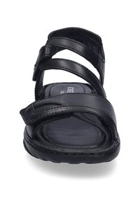 Černé kožené sandály s několika popruhy a měkčenou stélkou. Design zahrnuje plochou podrážku a texturovaný povrch.