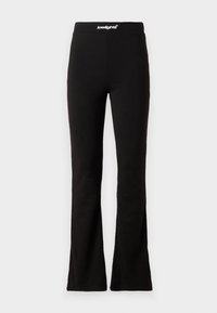 Leggings noires évasées avec une texture lisse et une taille élastique arborant un logo blanc. Conçus pour le confort et la flexibilité.